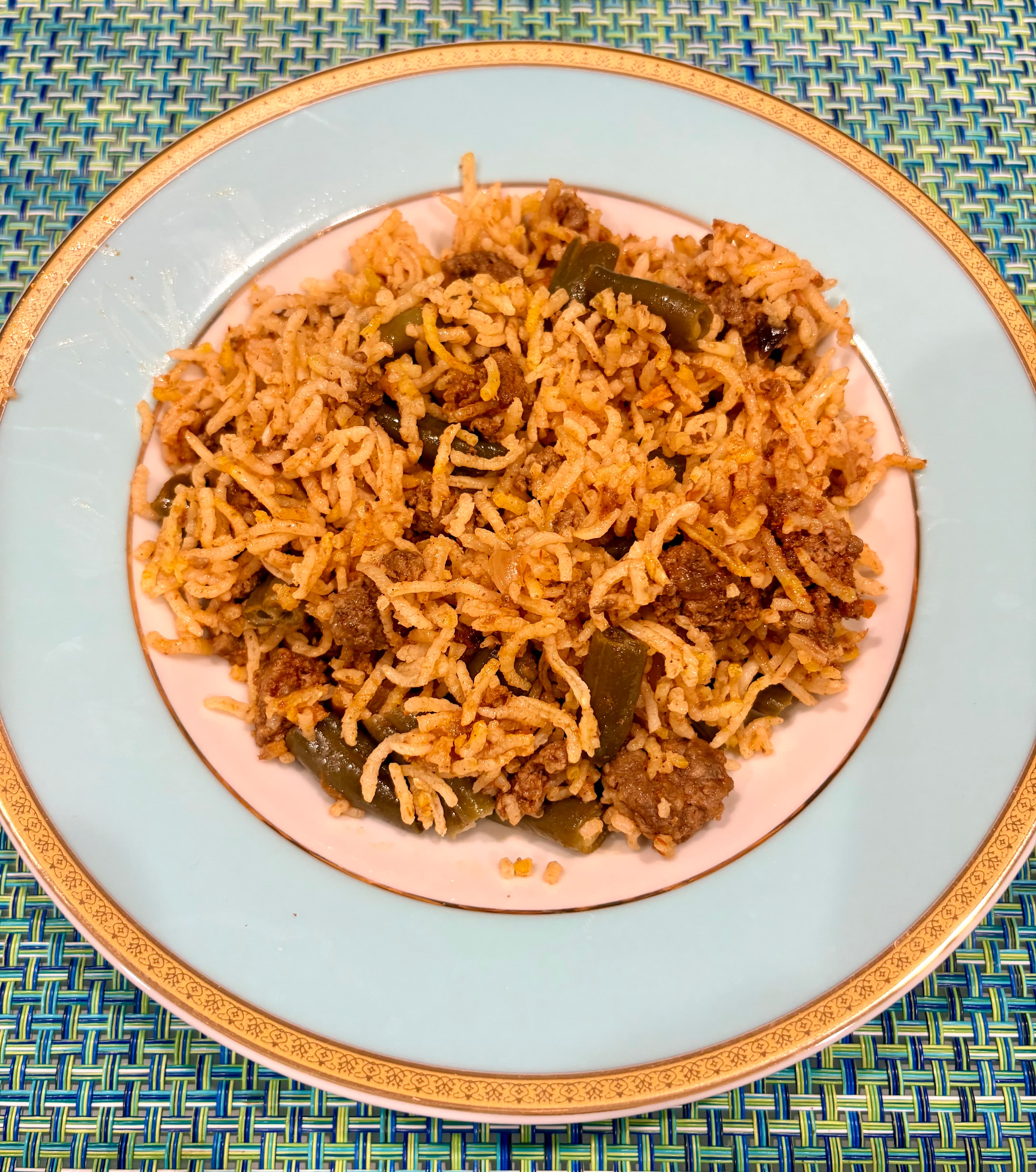 A plate of Persian green bean and ground beef rice, with rice, green beans, and ground beef mixed together